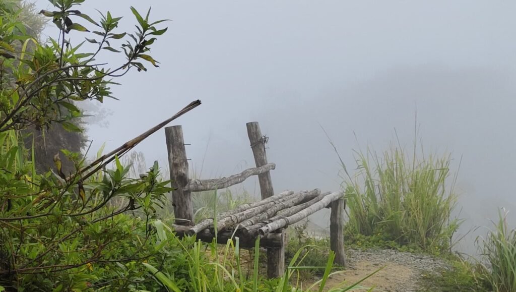 A thick blanket of white mist swirling around the mountain peak at Gongala, creating a surreal and ethereal landscape